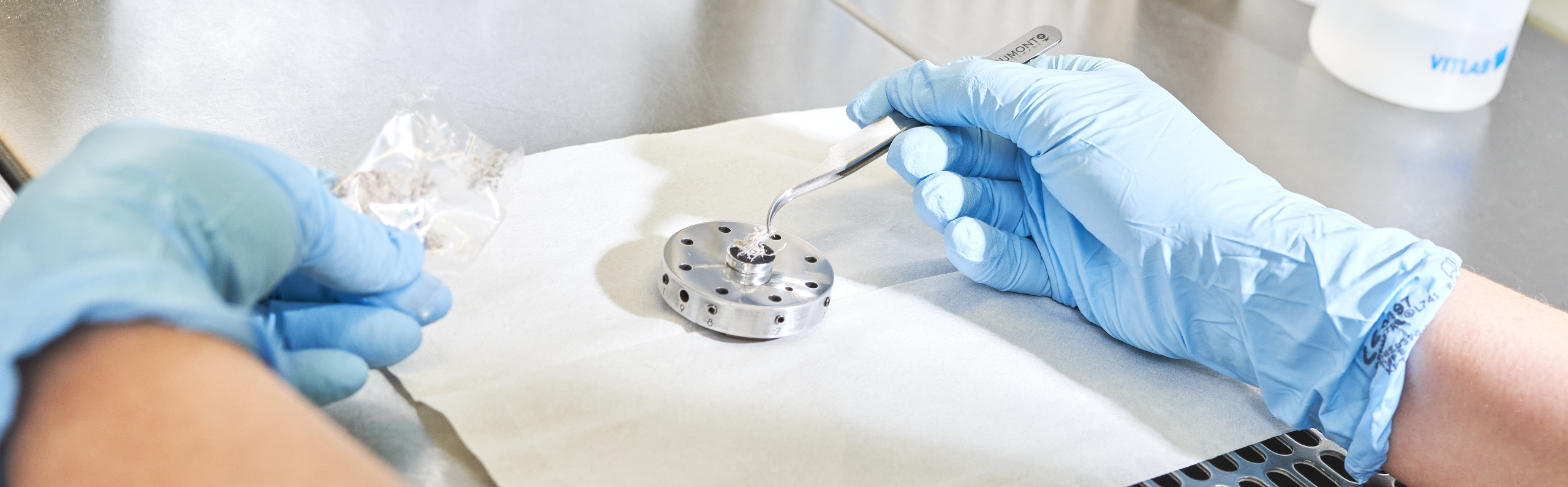 Probenvorbereitung einer Asbestprobe in einem Laborabzeug durch Mitarbeiter.